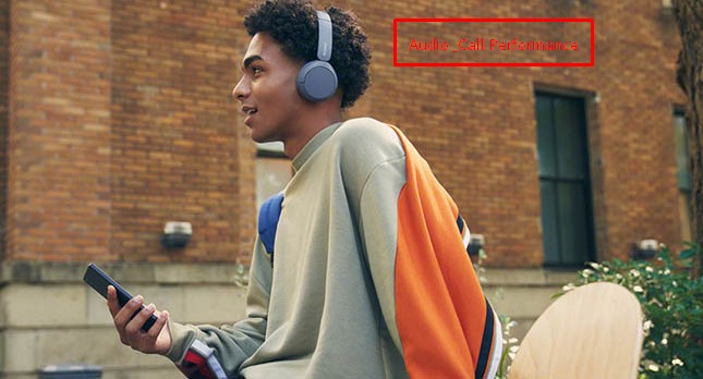 Man wearing blue Sony WH-CH520 headphones outdoors holding a phone, illustrating audio and call use