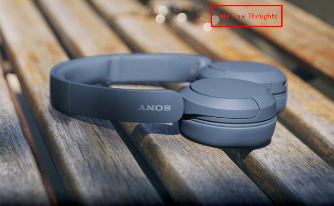 Blue Sony WH-CH520 headphones lying folded on wooden slats