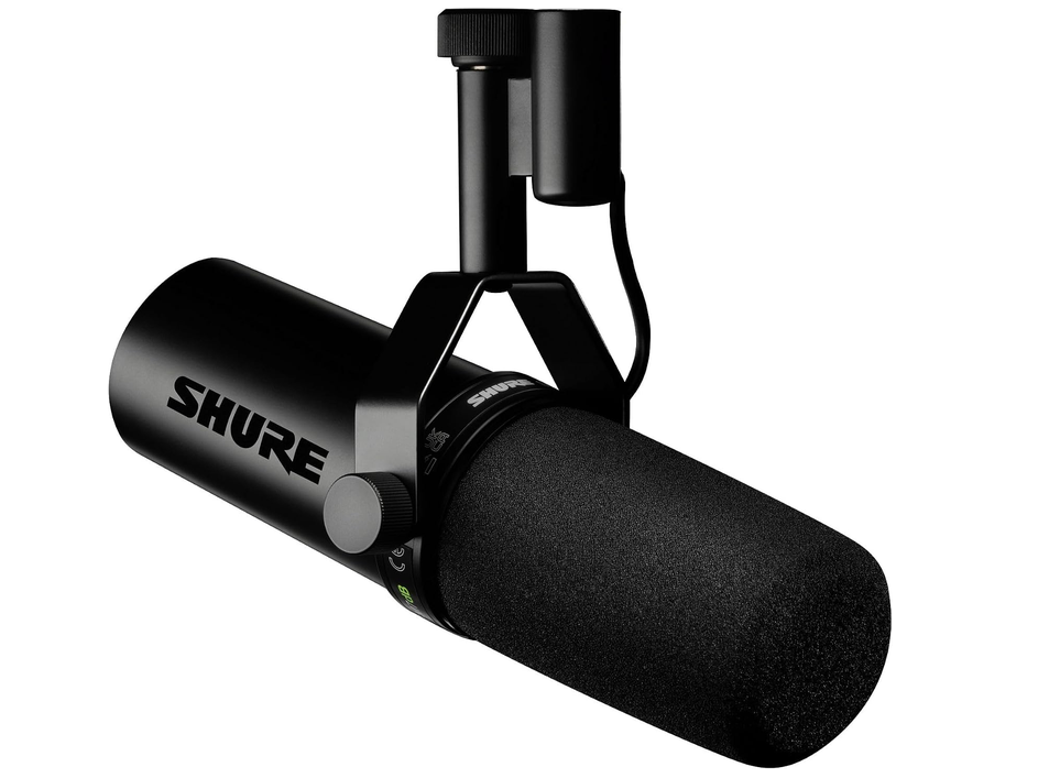 Black Shure microphone with foam windscreen on its yoke mount