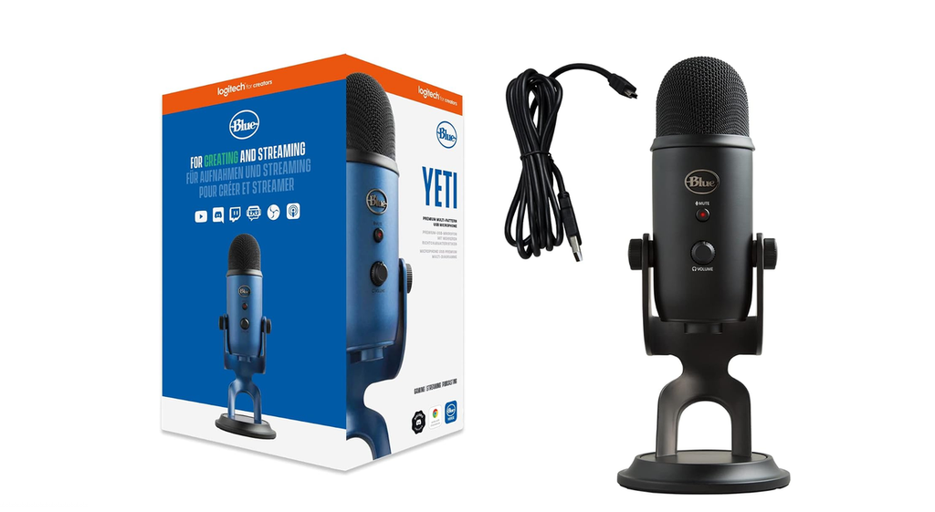 Blue Yeti USB microphone in black on its desk stand beside its blue retail box and coiled USB cable